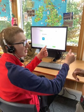 Boy sitting at a computer working on a DoE project