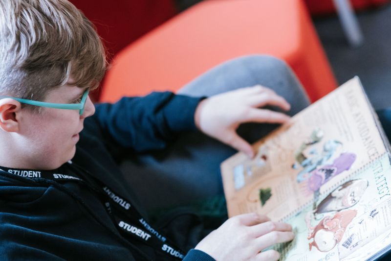 Boy reading a book whilst sat on a beanbag