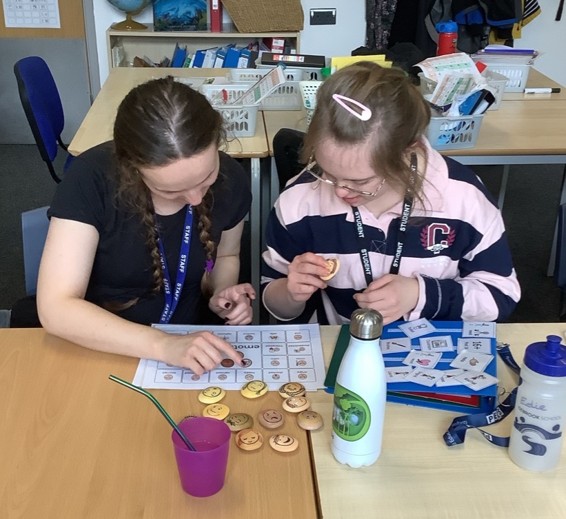 Student and staff member using symbols to communicate